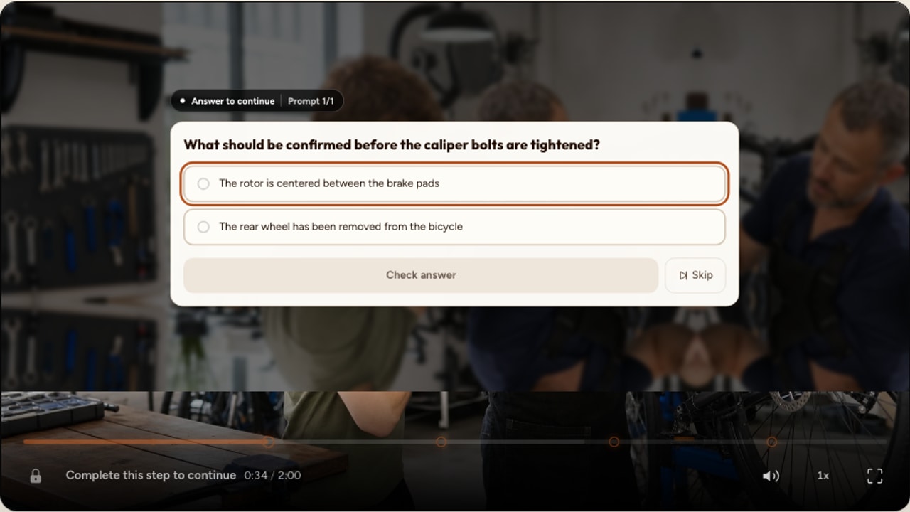 A real Interakly question over a bicycle repair lesson with several lesson moments visible on the player timeline